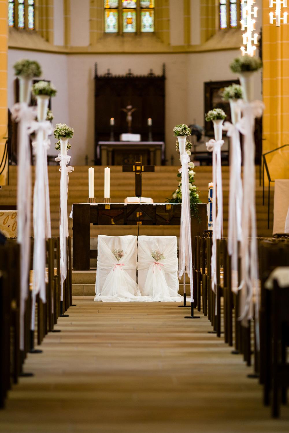Festlich geschmückter Mittelgang der Stiftskirche in Herrenberg mit dekorierten Stühlen vor dem Altar.