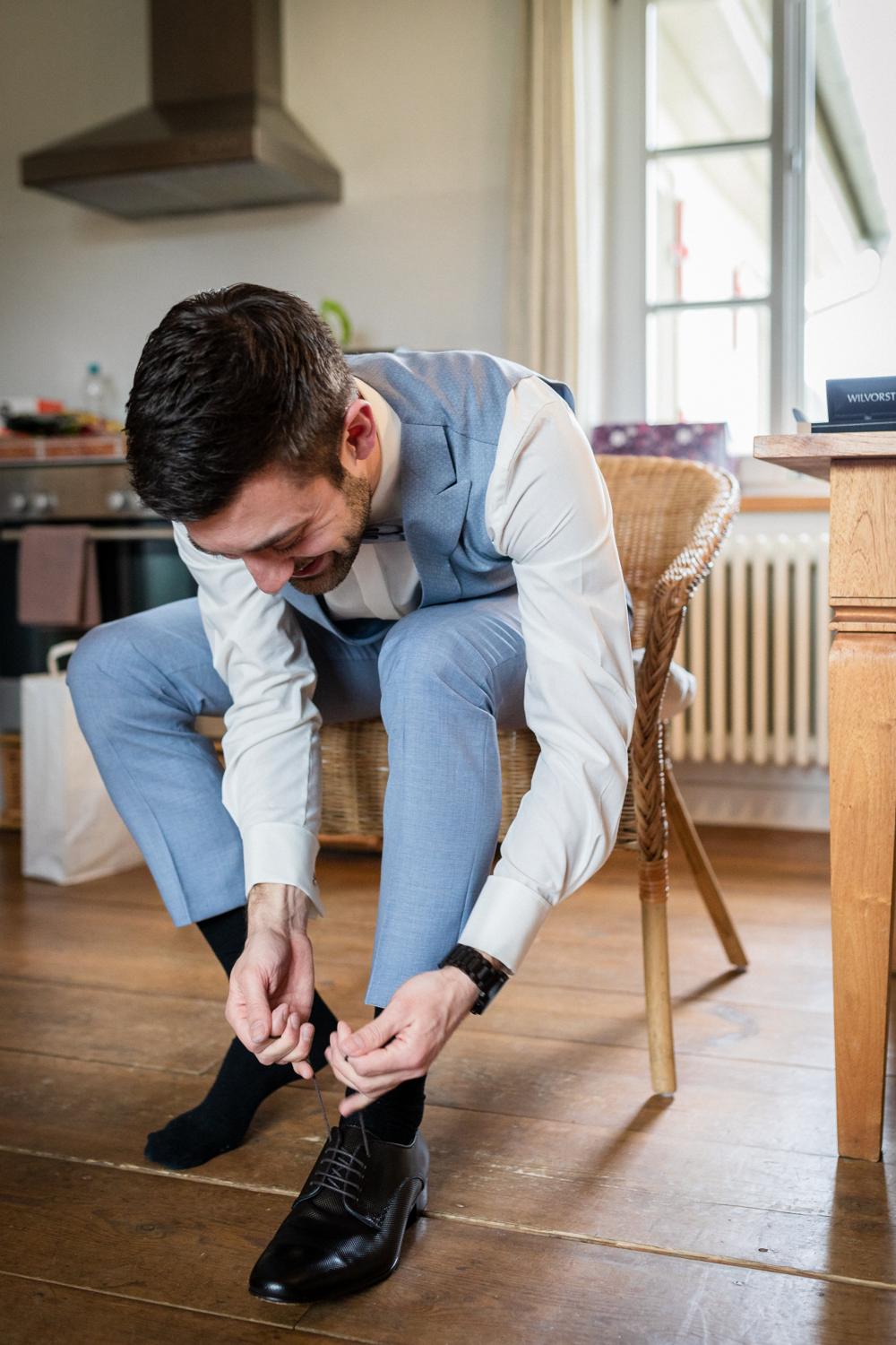 Bräutigam bindet sich seine Schuhe vor der Hochzeit