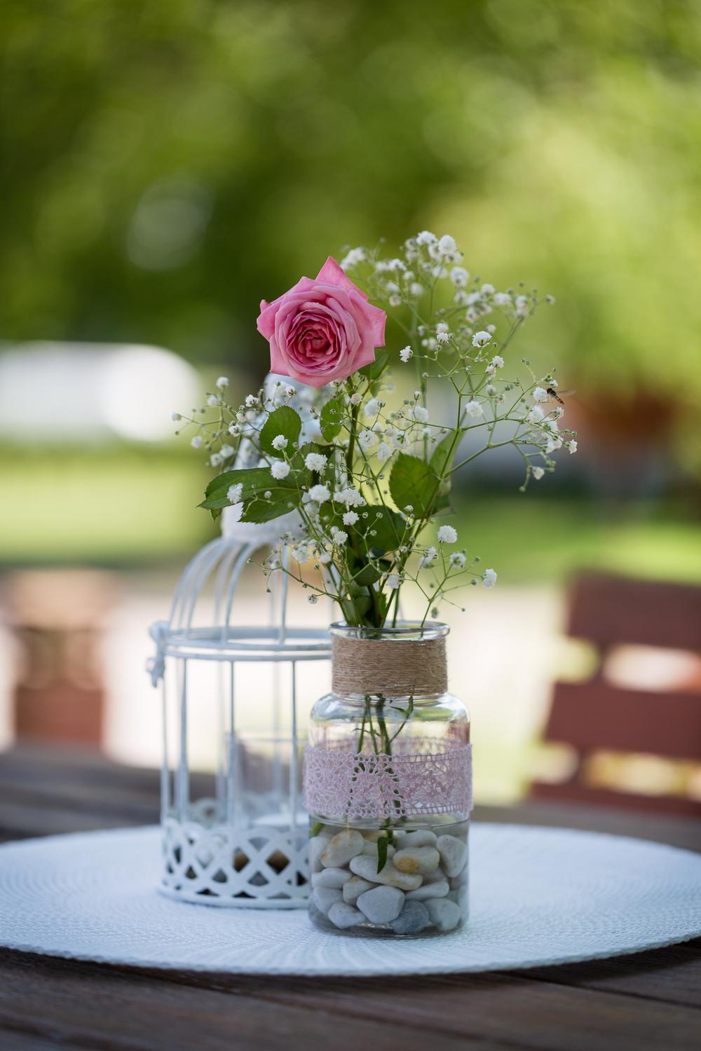 Tischdeko mit Rose und Schleierkraut im Spitzenglas