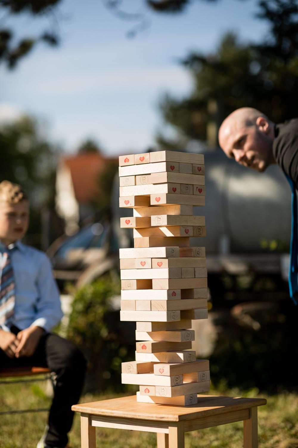 Hochzeitsgast spielt riesiges Jenga im Garten der Hofschuir