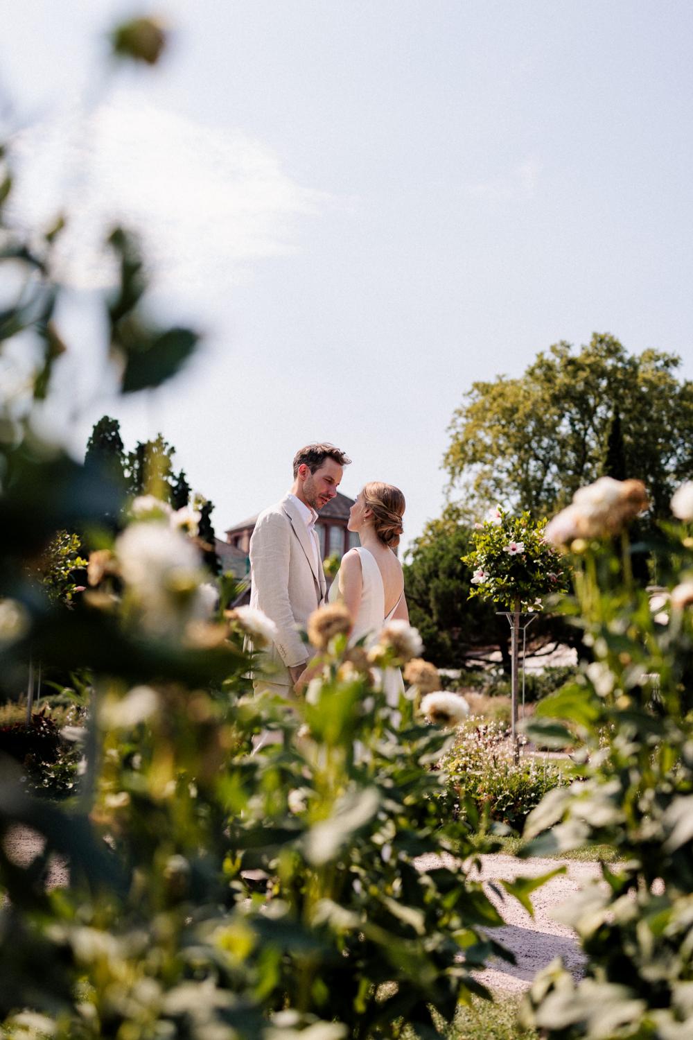 Brautpaar zwischen hohen Dahlienbeeten im sonnigen Botanischen Garten Karlsruhe