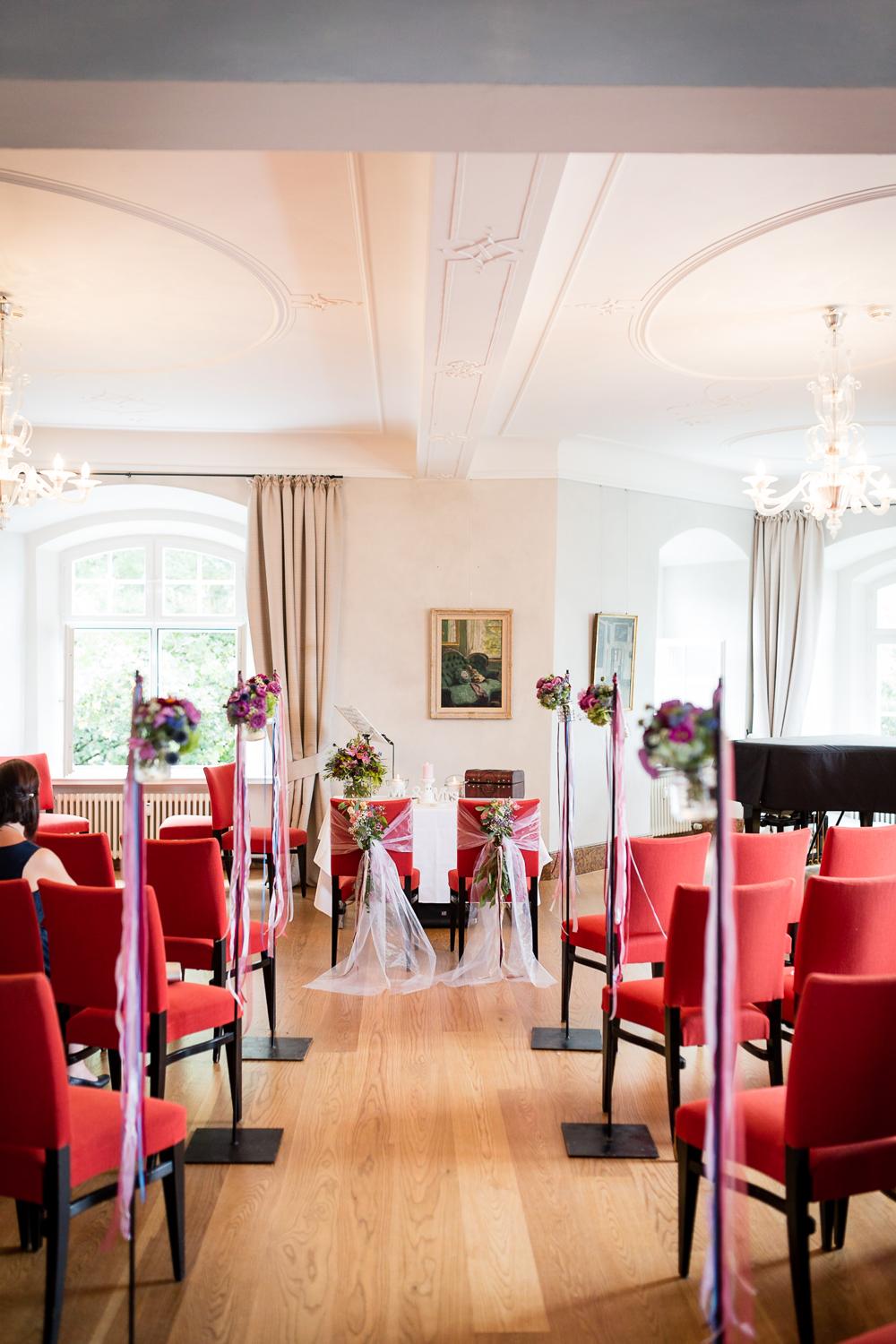 Trauzimmer im Schloss Filseck mit roten Stühlen und Blumendeko