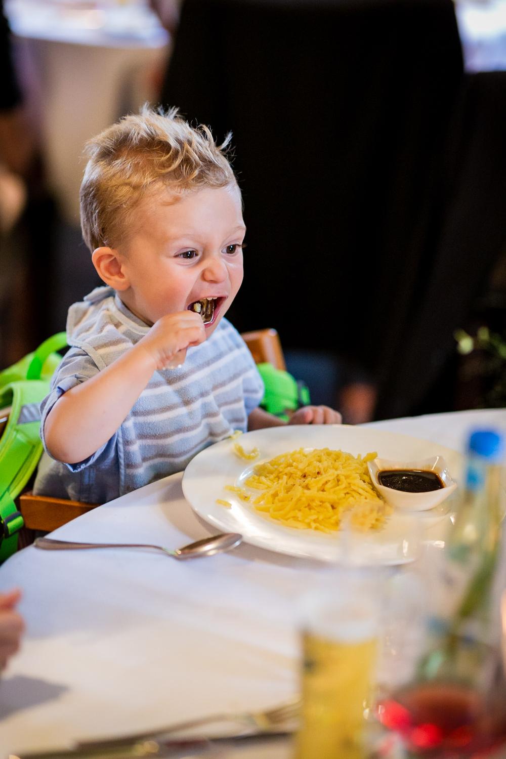 Kleiner Hochzeitsgast isst genüsslich Spätzle am Kindertisch