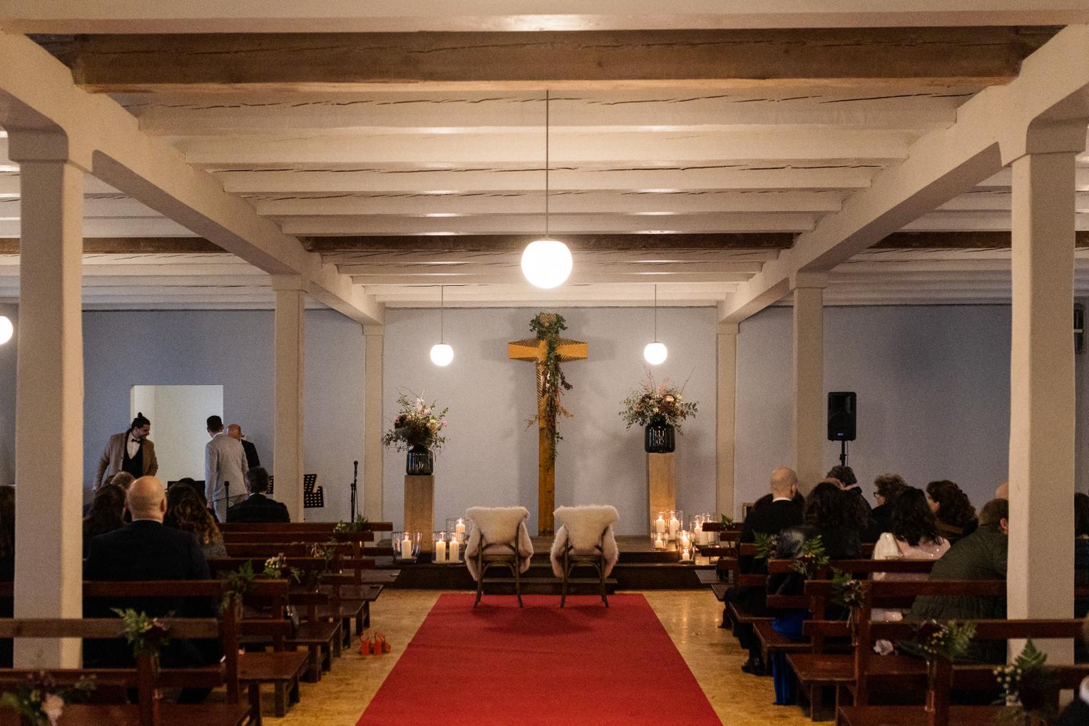 Innenraum der Franziskus Kapelle auf dem Albgut mit rotem Teppich und Lederstühlen