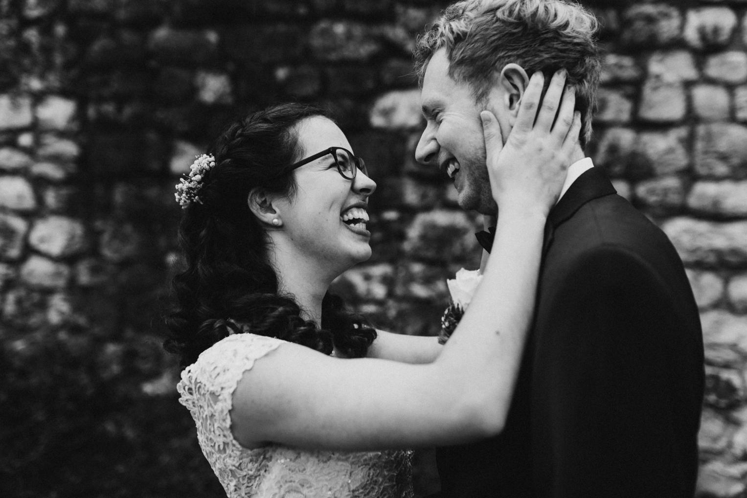 Braut und Bräutigam lachen sich ausgelassen an, Schwarz-Weiß-Portrait auf der Burg Veringenstadt