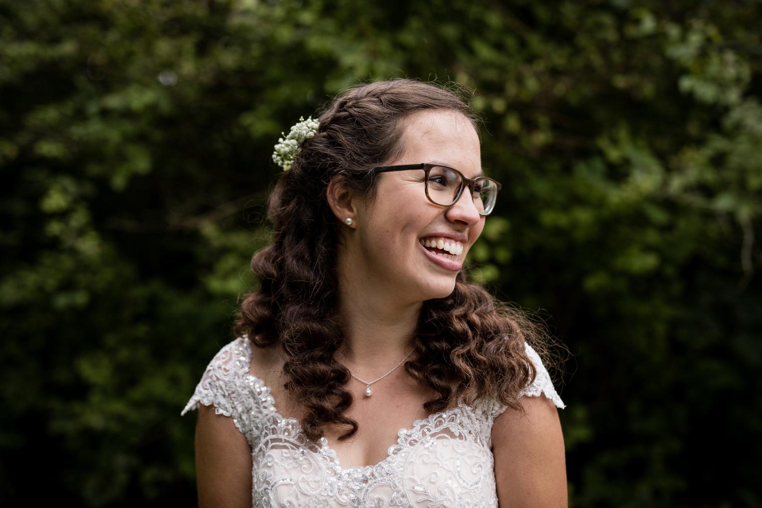 Portrait der strahlenden Braut mit Blumenhaarschmuck und Spitzenkleid, Burg Veringenstadt