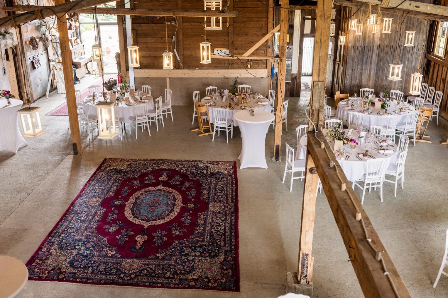 Blick von oben in den festlich dekorierten Festsaal der Lindenhof-Scheune mit Orientteppich