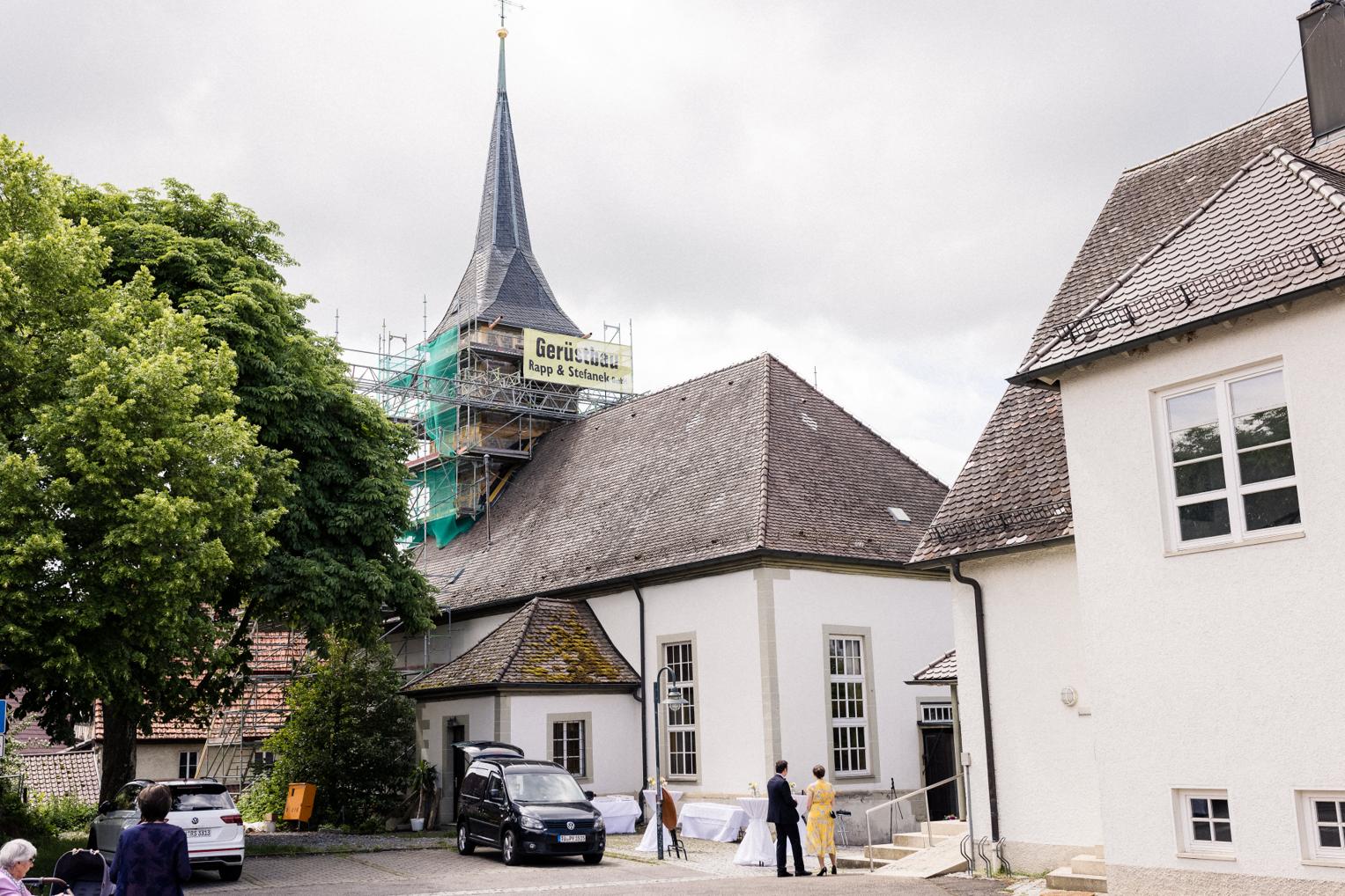 Ankunft des Brautpaars an der Mauritius Kirche Mötzingen mit Kirchturm und Gerüst im Hintergrund