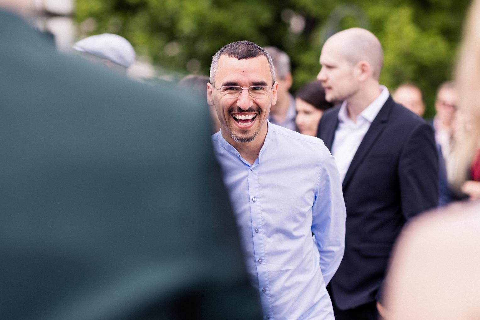 Gäste lachen ausgelassen beim Sektempfang nach der Trauung an der Mauritius Kirche Mötzingen