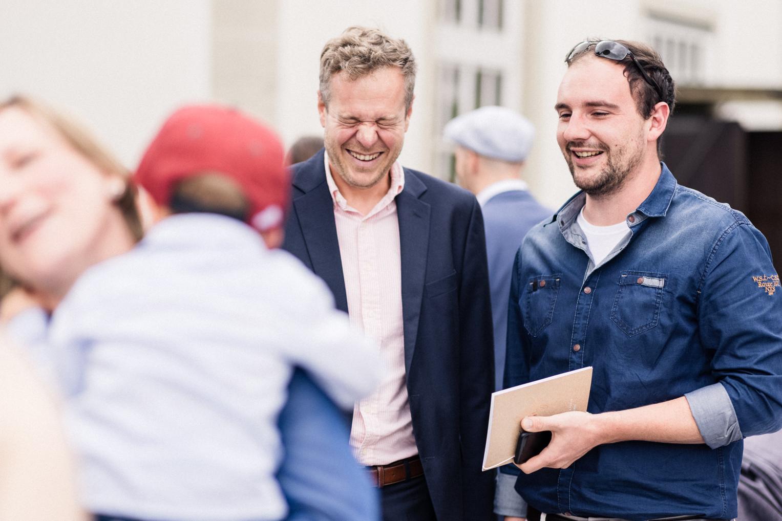 Gäste lachen gemeinsam beim Empfang vor der Mauritius Kirche Mötzingen nach der Trauung