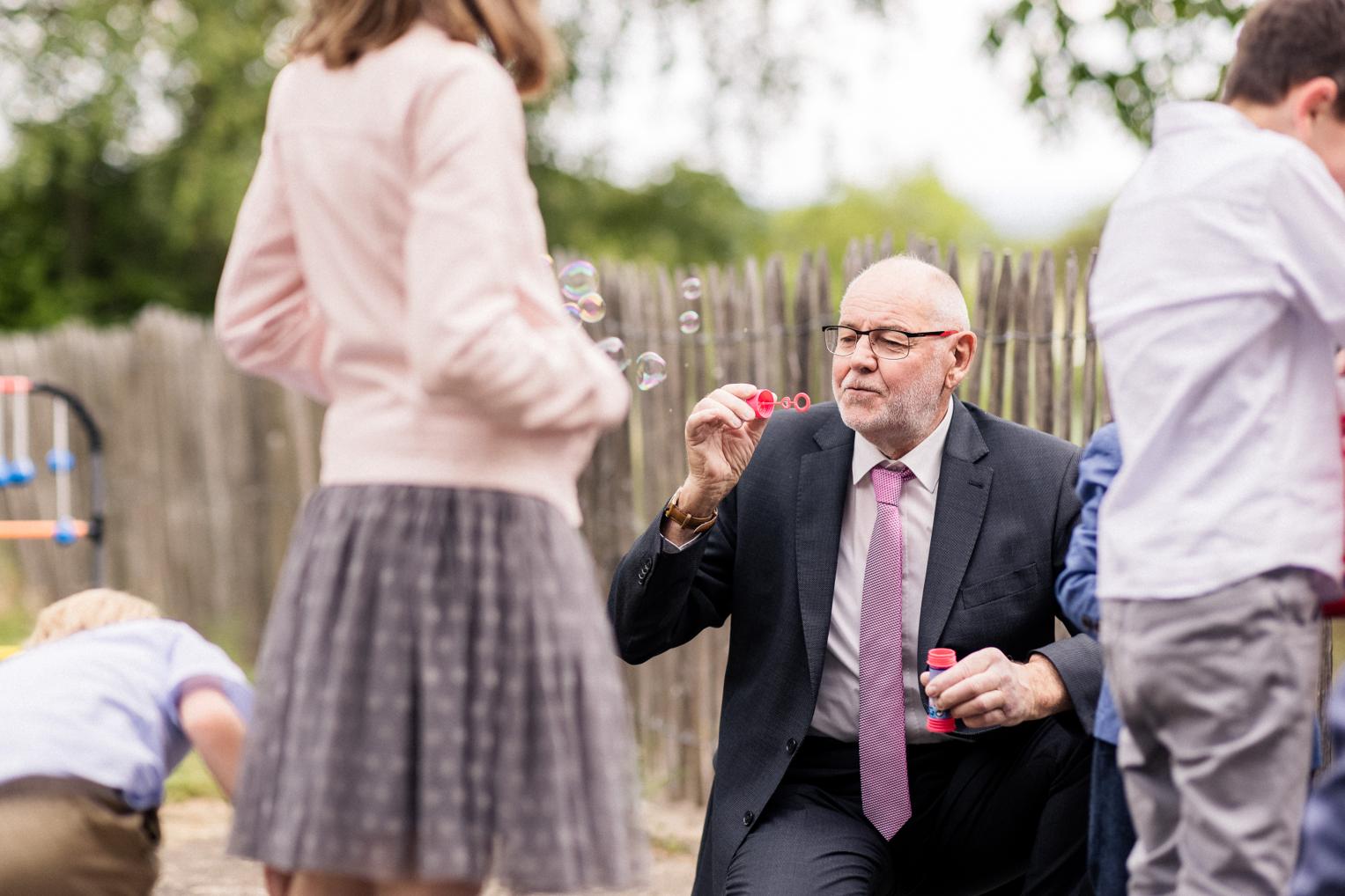 Gast pustet Seifenblasen für Kinder bei der Hochzeitsfeier im Garten des Lindenhof Mötzingen