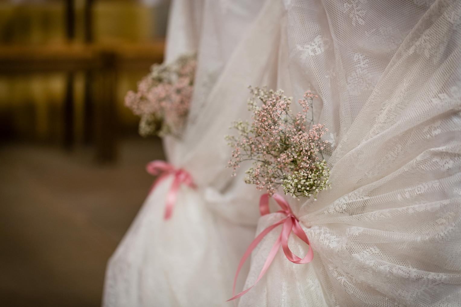 Detailaufnahme einer mit Blumen und Schleifen dekorierten Stuhllehne bei einer Trauung in der Stiftskirche Herrenberg.