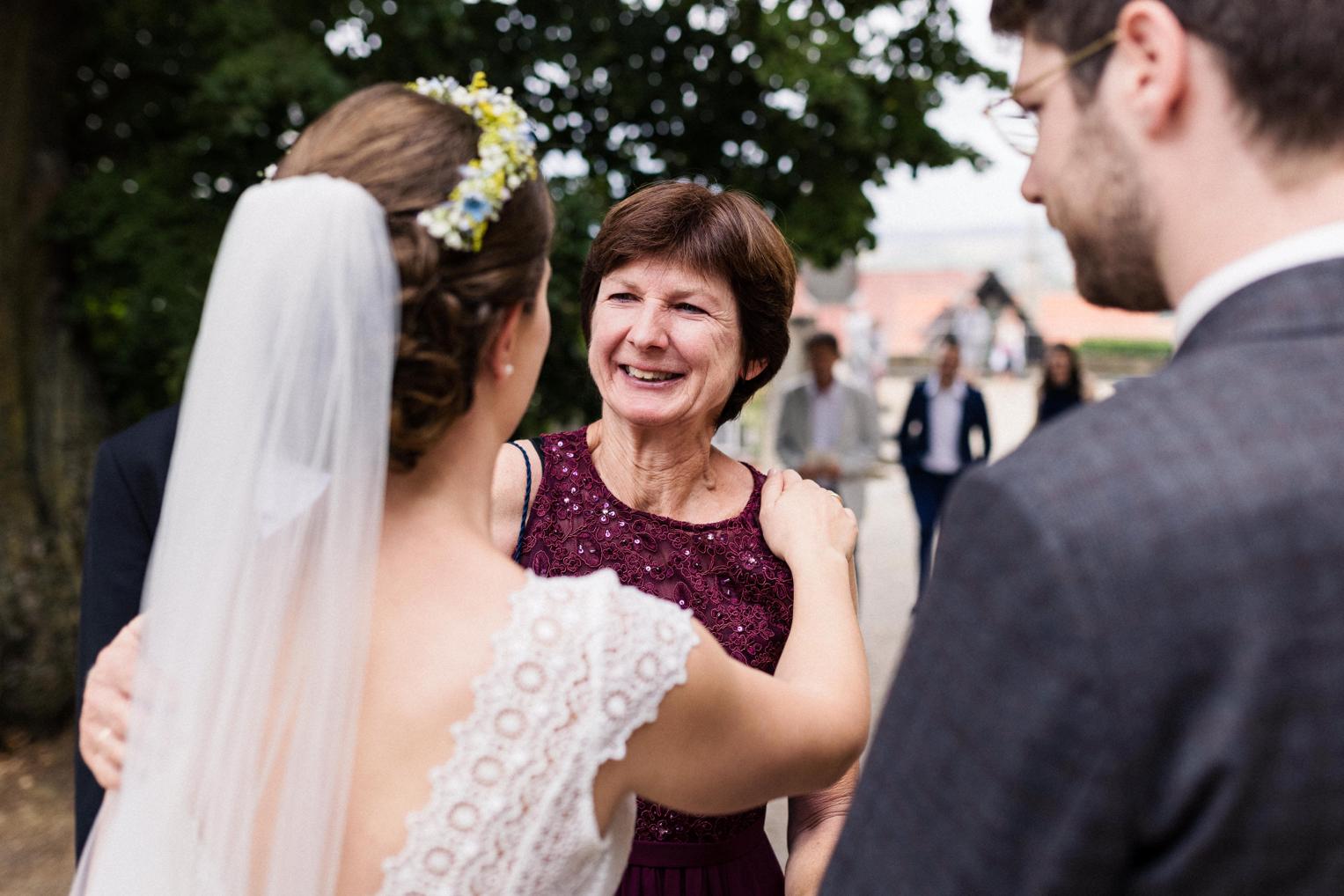 Braut umarmt eine ältere Frau vor der Stiftskirche Herrenberg nach der Trauung.