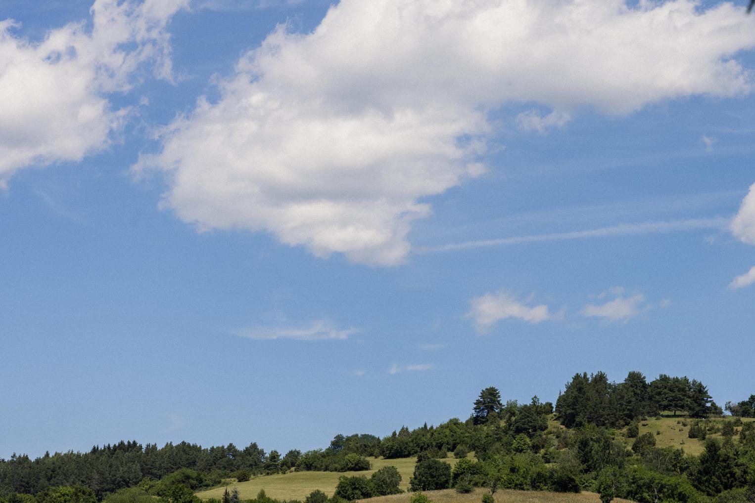 Blick über bewaldete Hügel unter blauem Sommerhimmel mit Schäfchenwolken – Auftakt eines Hochzeitstages bei Freudenstadt