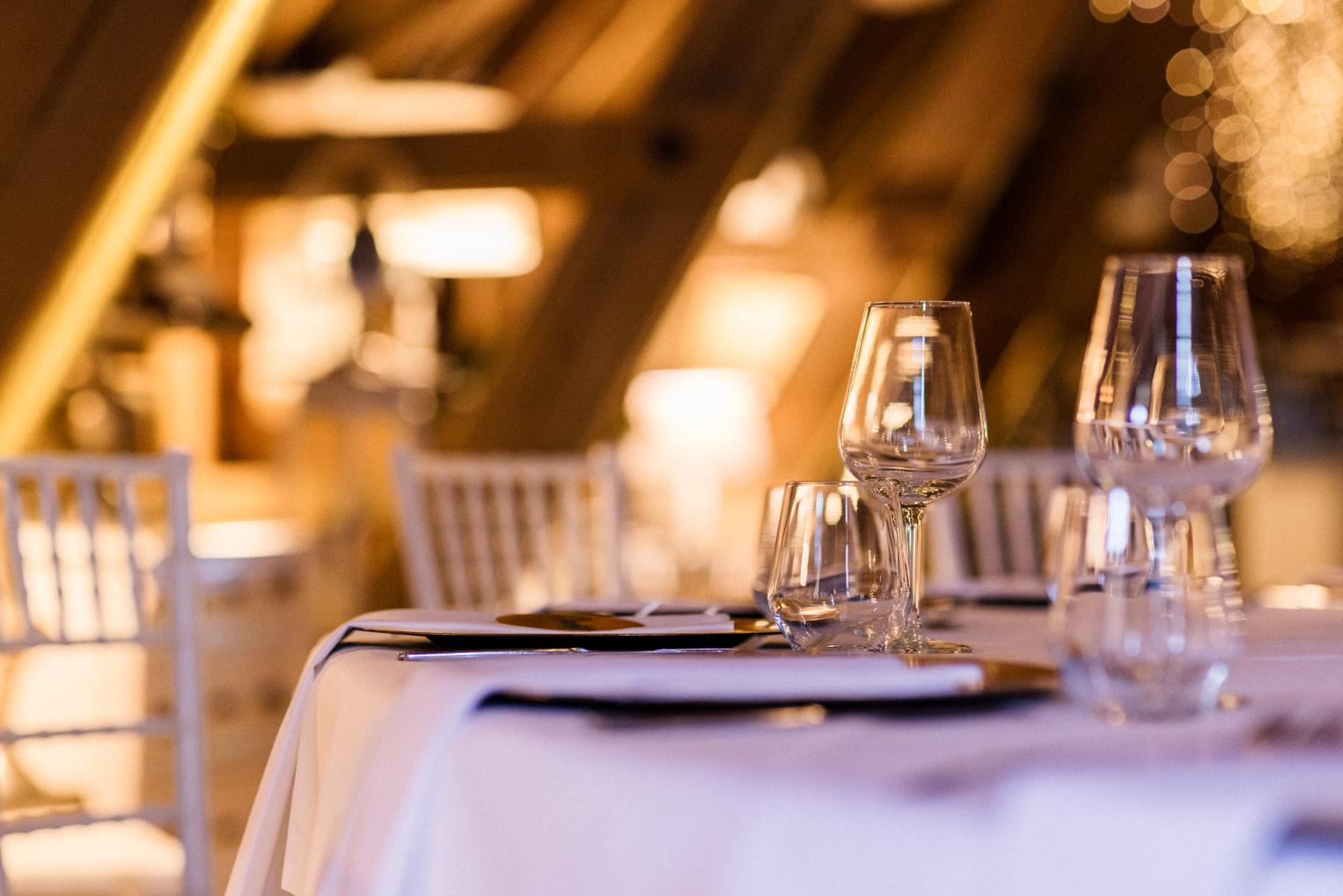 Gedeckter Tisch mit Weingläsern im warmen Licht des Festsaals im Bärenschlössle