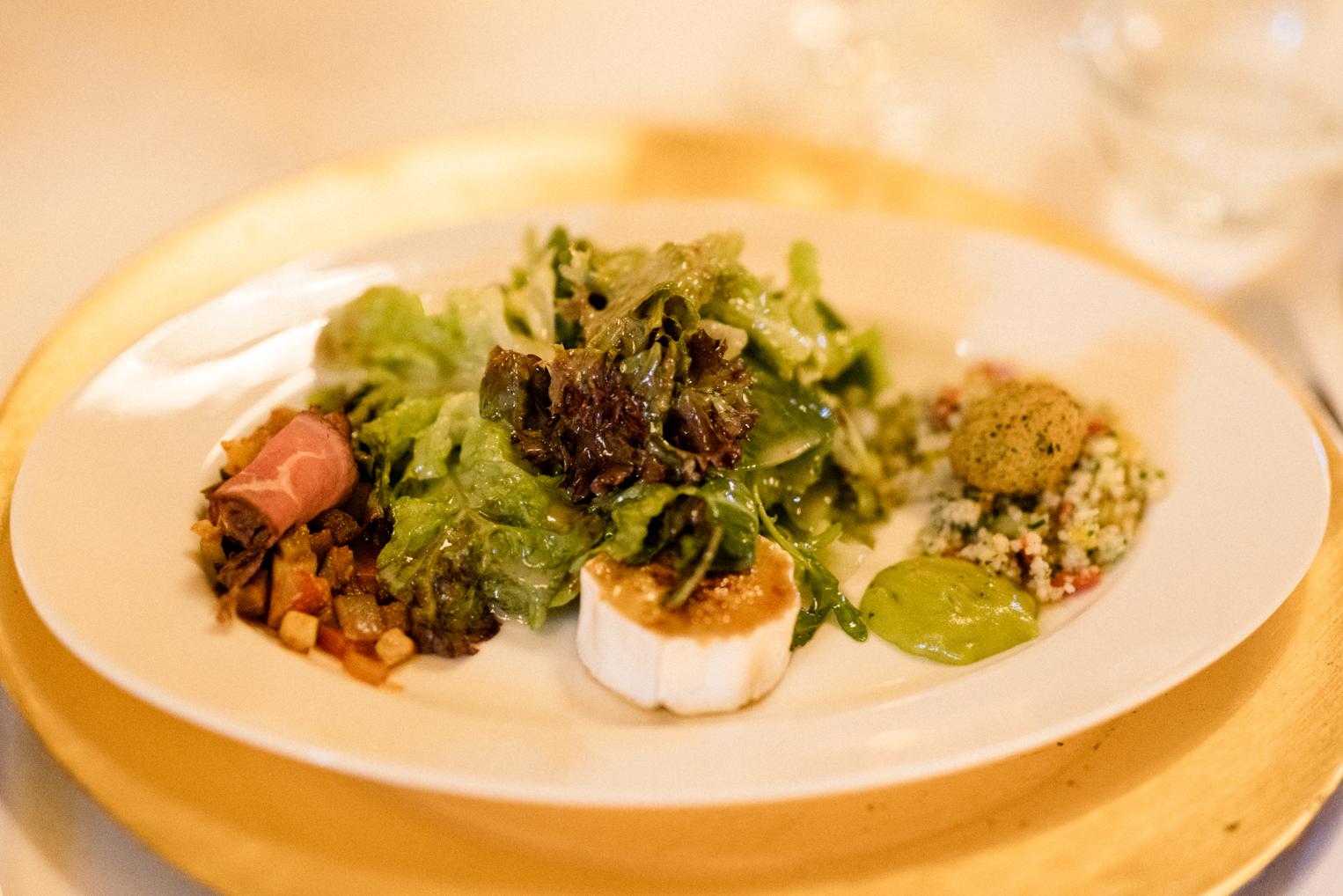 Vorspeise mit Salat, Ziegenkäse und Couscous auf goldenem Teller im Bärenschlössle