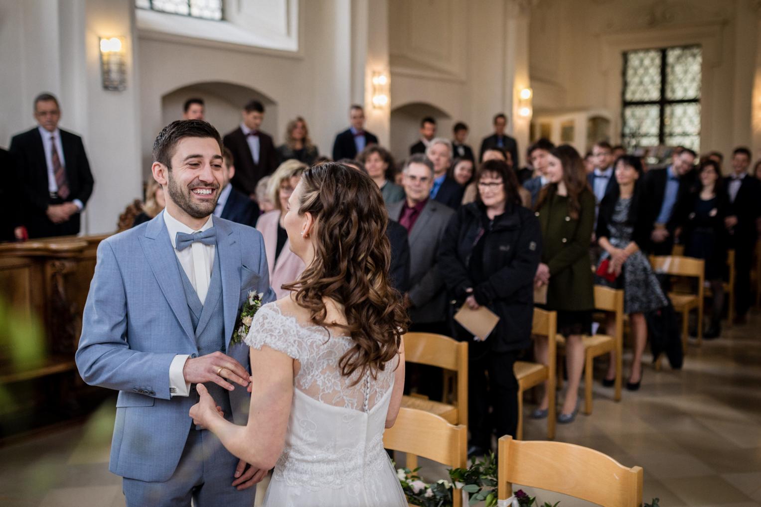 Braut und Bräutigam lachen sich vor den Gästen verliebt an
