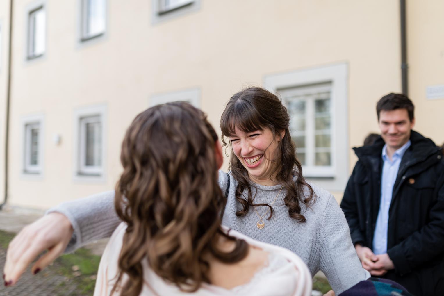 Freudige Begrüßung der Braut durch eine Freundin vor dem Kloster