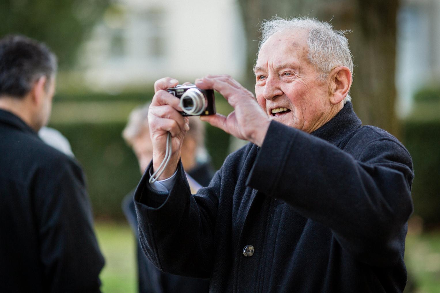 Älterer Hochzeitsgast fotografiert mit Kompaktkamera