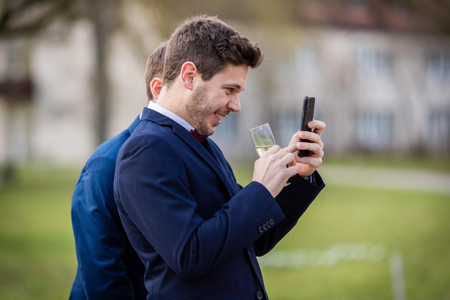 Gast macht ein Foto mit dem Handy beim Sektempfang
