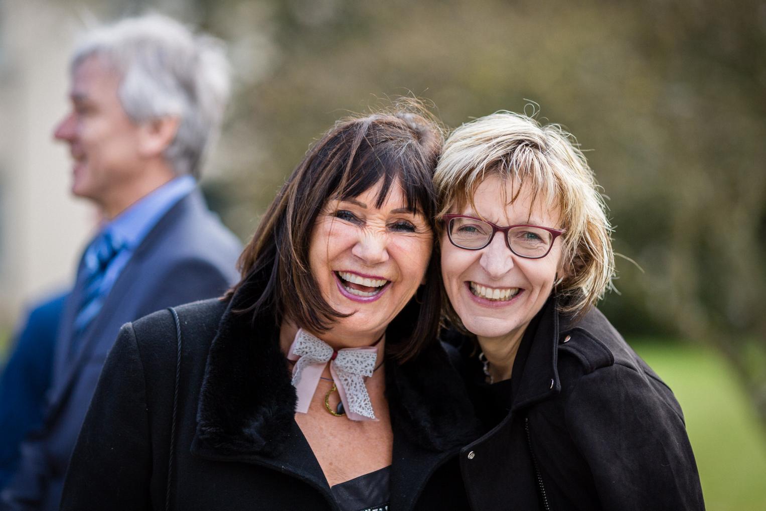 Zwei beste Freundinnen lachen herzlich am Tag der Hochzeit