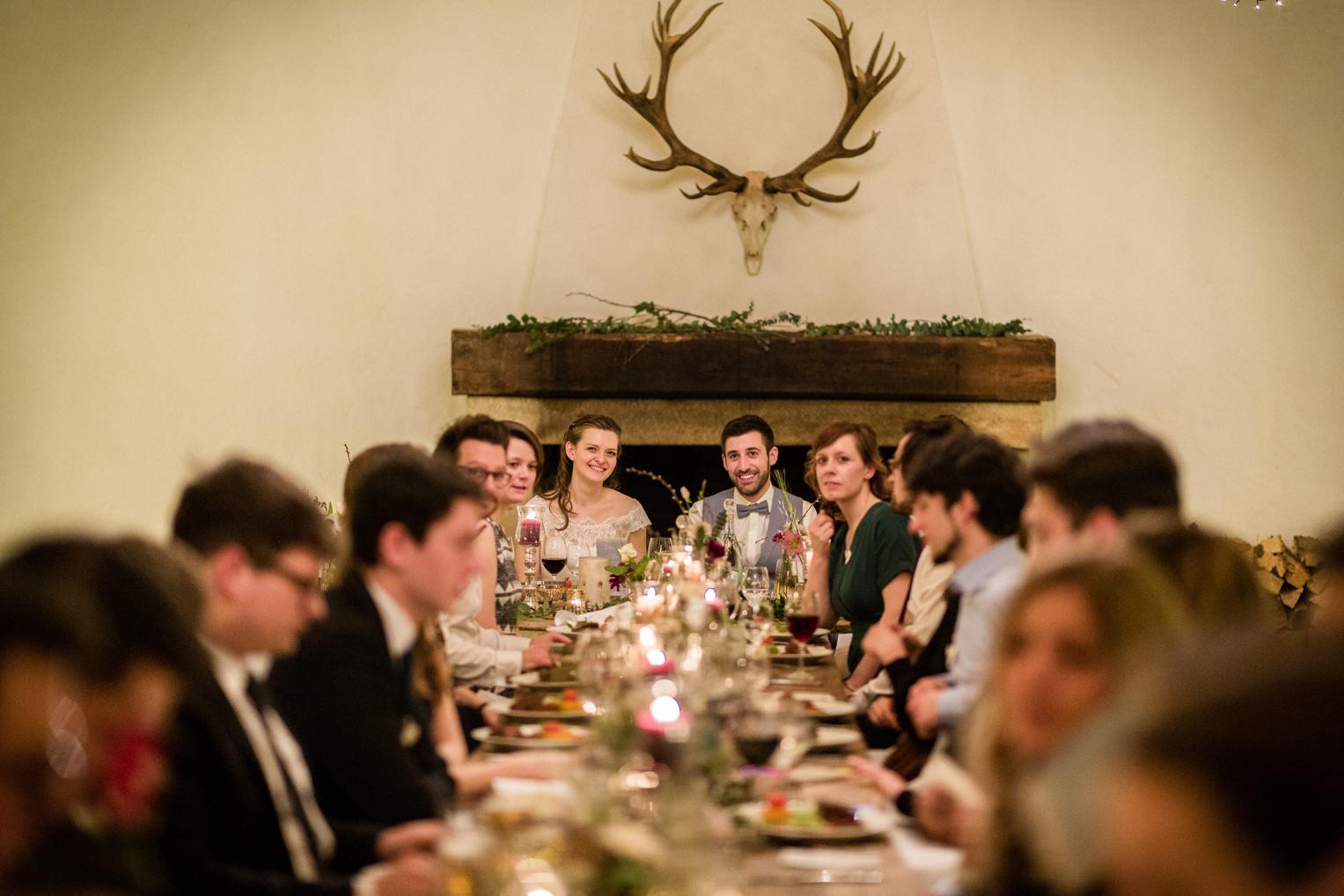 Brautpaar an der Tafel vor Kamin mit Hirschgeweih in der Maisenburg