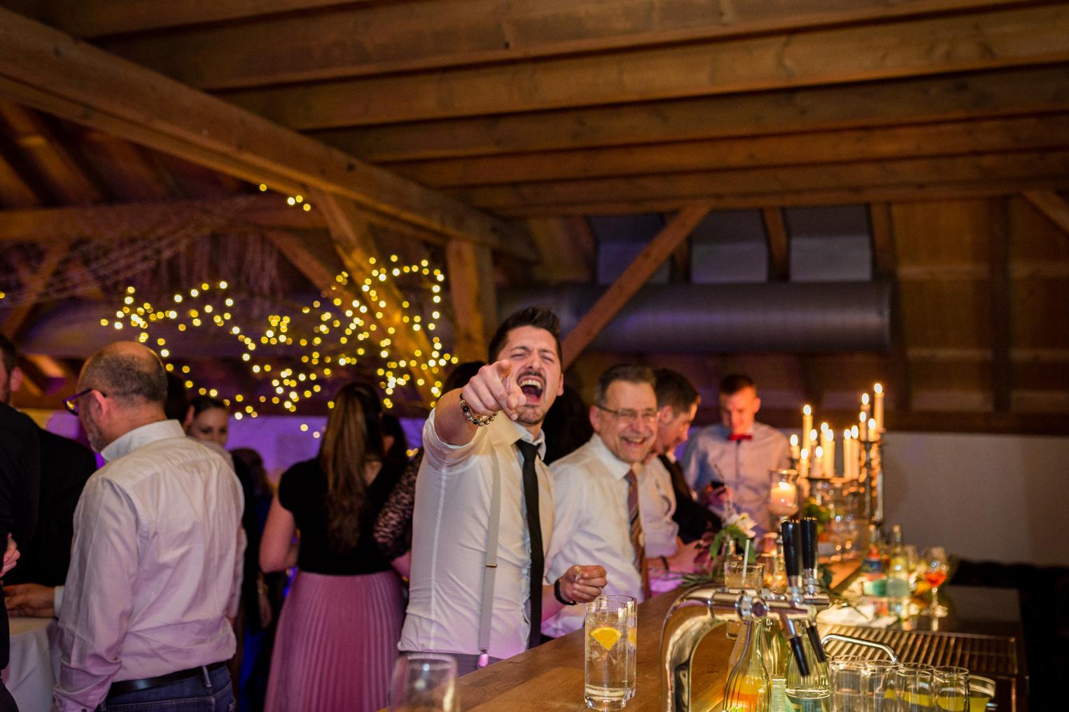 Gut gelaunter Hochzeitsgast an der Bar des Festsaals