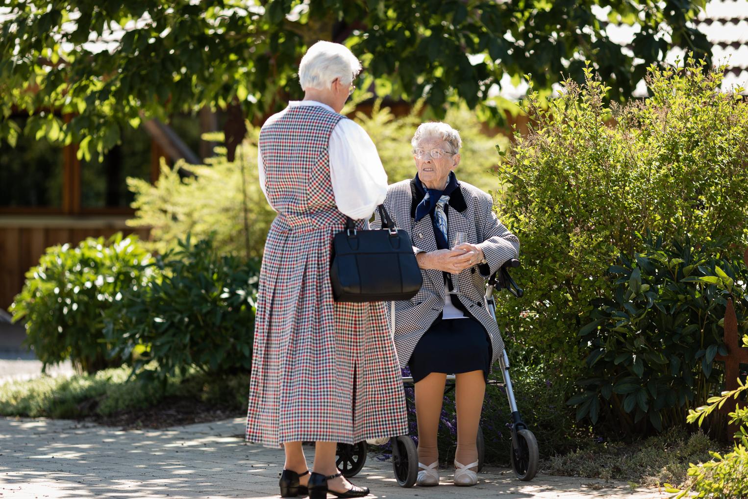 Zwei ältere Hochzeitsgäste plaudern im Garten der Hofschuir