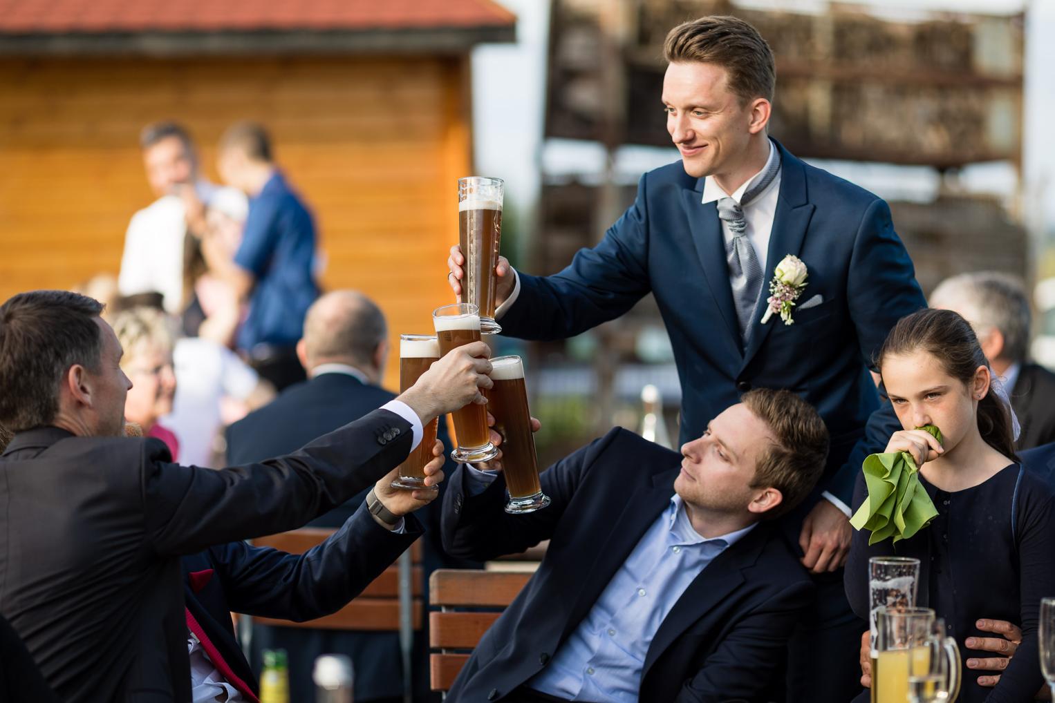 Trauzeugen stoßen mit Weizenbier auf den Bräutigam an