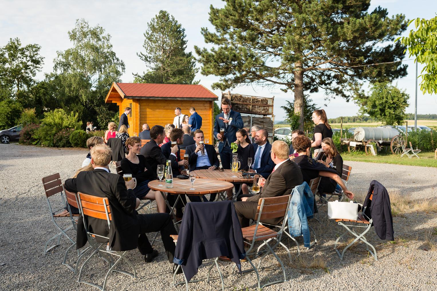 Hochzeitsgäste sitzen im Biergarten vor der Hofschuir Bondorf