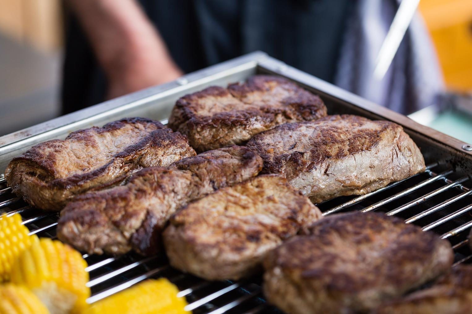 Saftige Steaks und Maiskolben auf dem Grill der Hofschuir