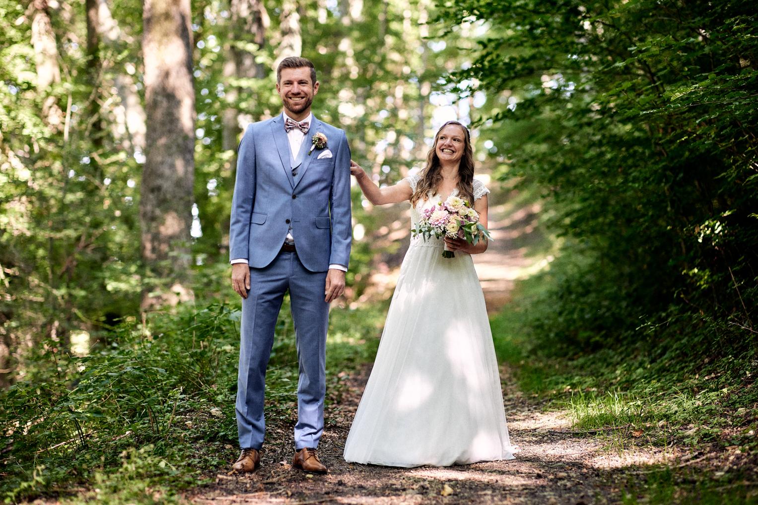 Brautpaar lacht beim First Look am Waldweg bei Owen