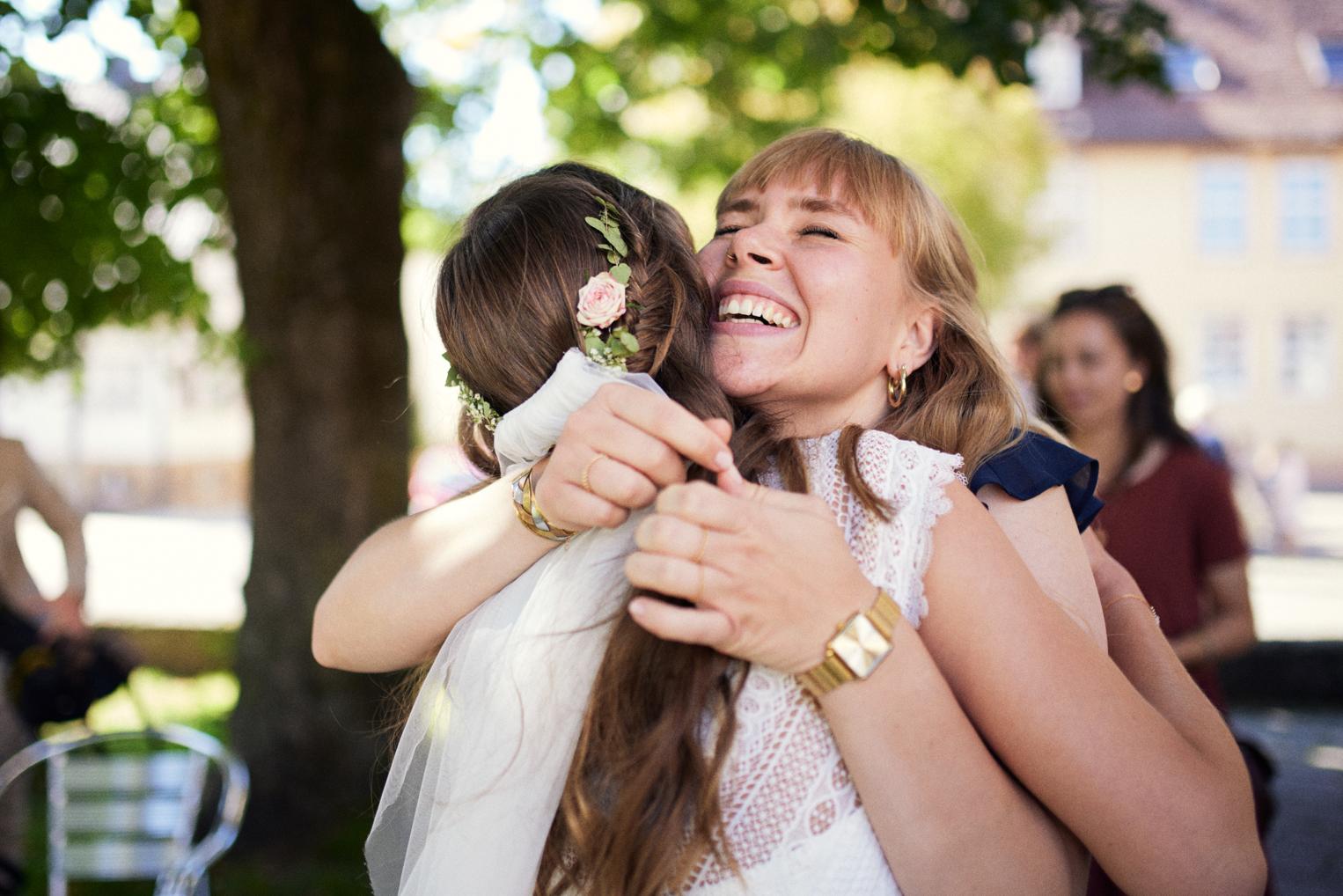 Freundin umarmt die Braut emotional beim Gratulieren