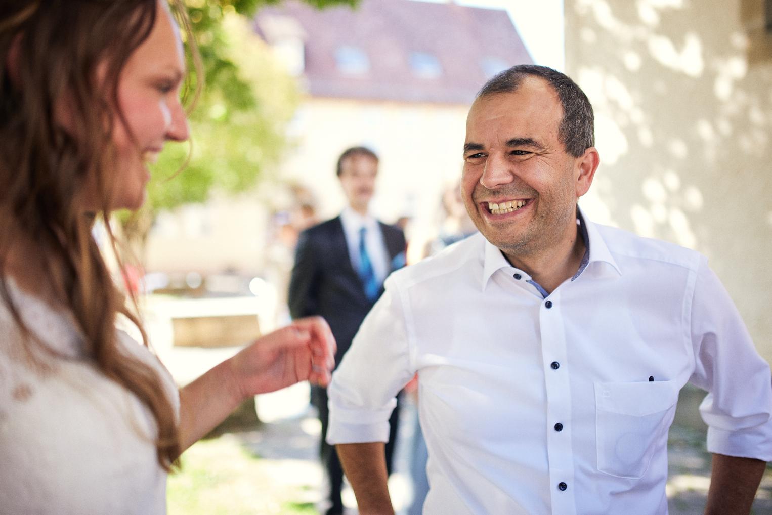 Vater lacht herzhaft mit seiner frisch vermählten Tochter