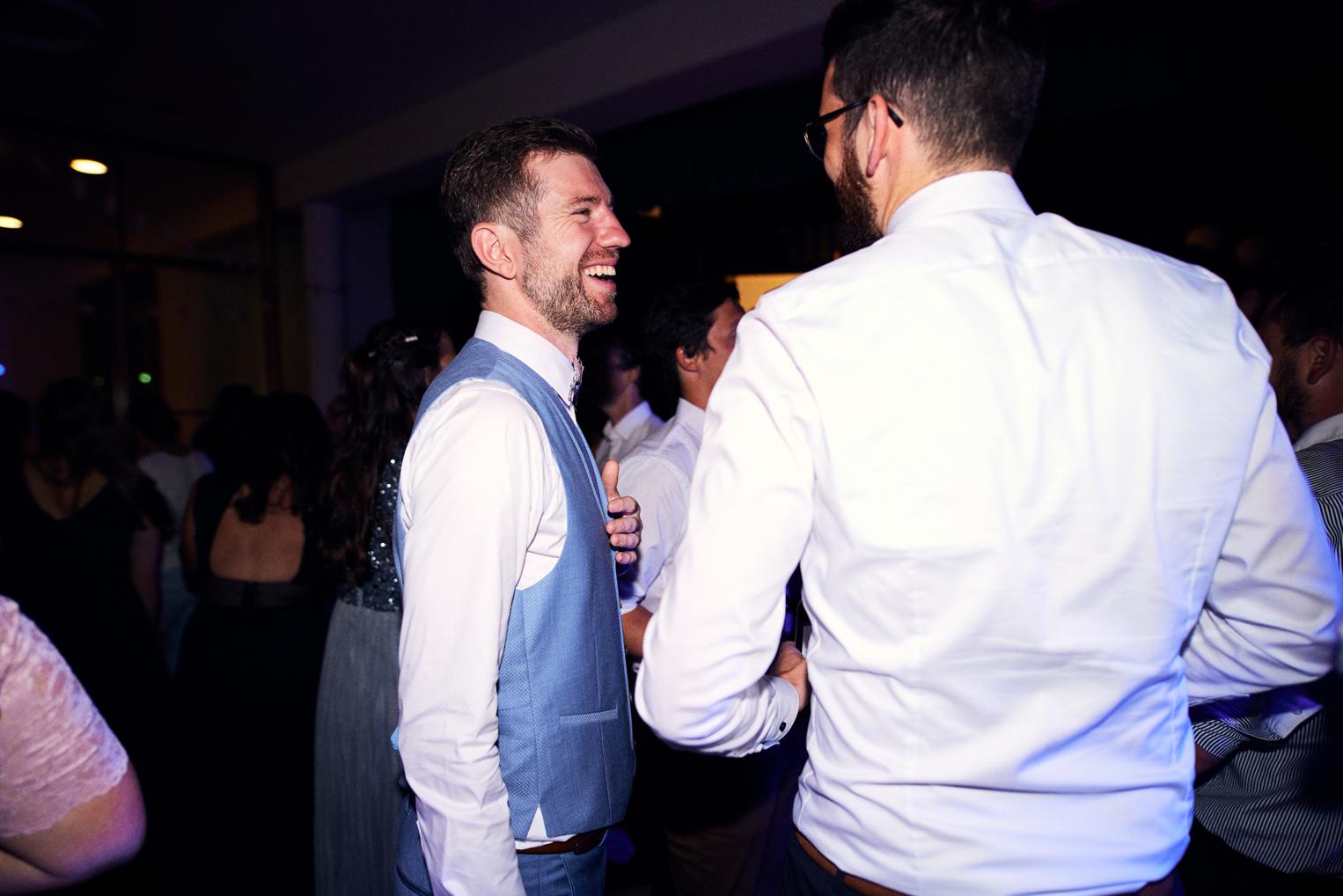 Bräutigam lacht entspannt mit einem Freund auf der Party