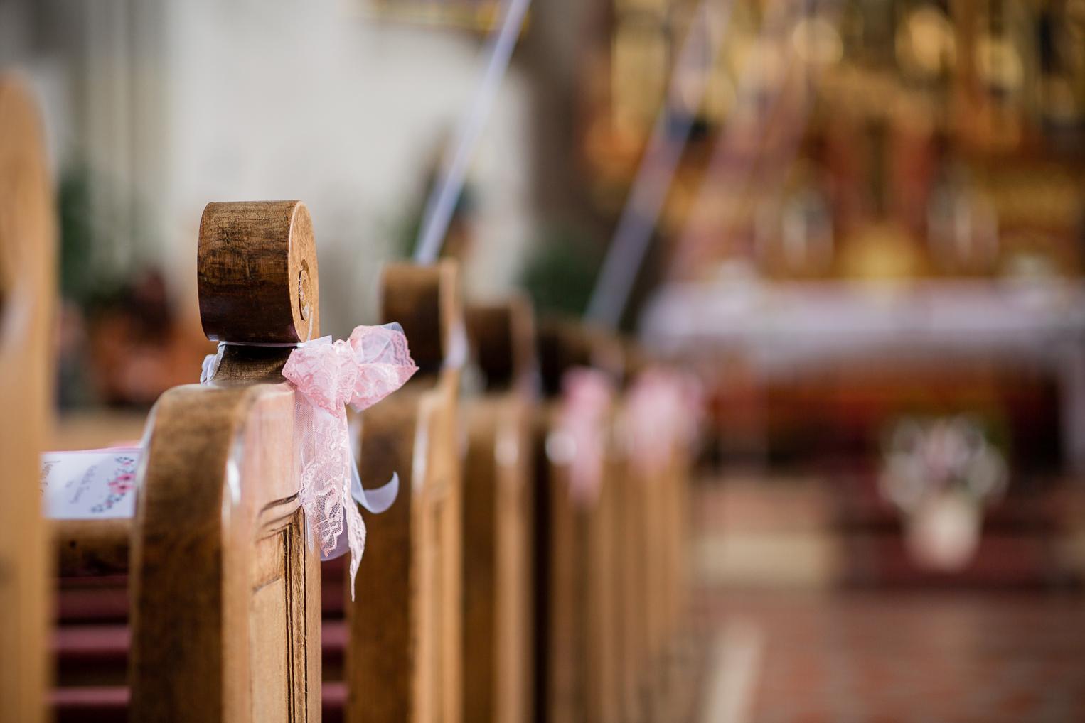 Detail: Kirchenbank mit rosa Spitzenschleife dekoriert, Trauung St. Clemenskirche Gruol