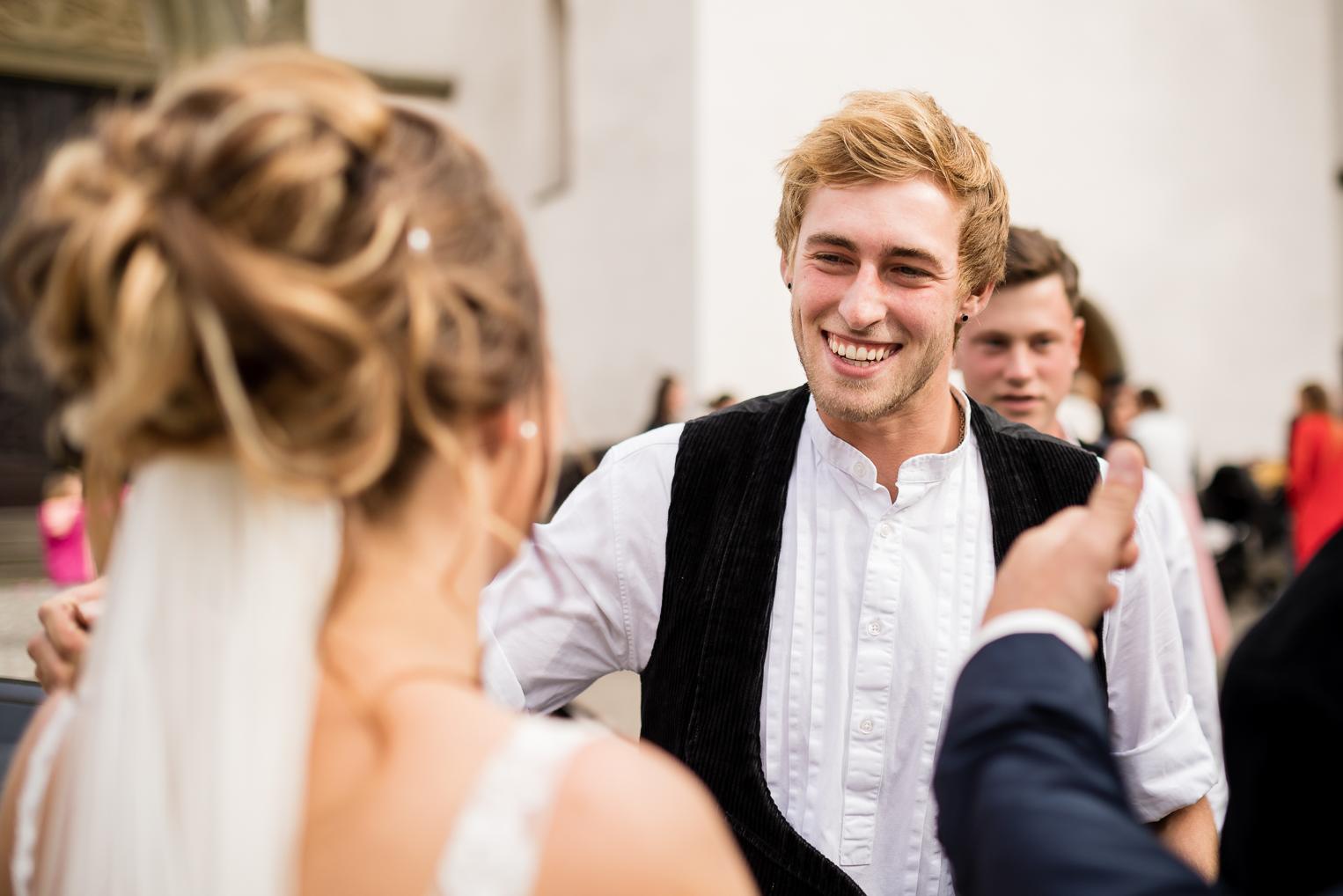 Gast gratuliert der Braut lachend nach der Trauung in der St. Clemenskirche Gruol