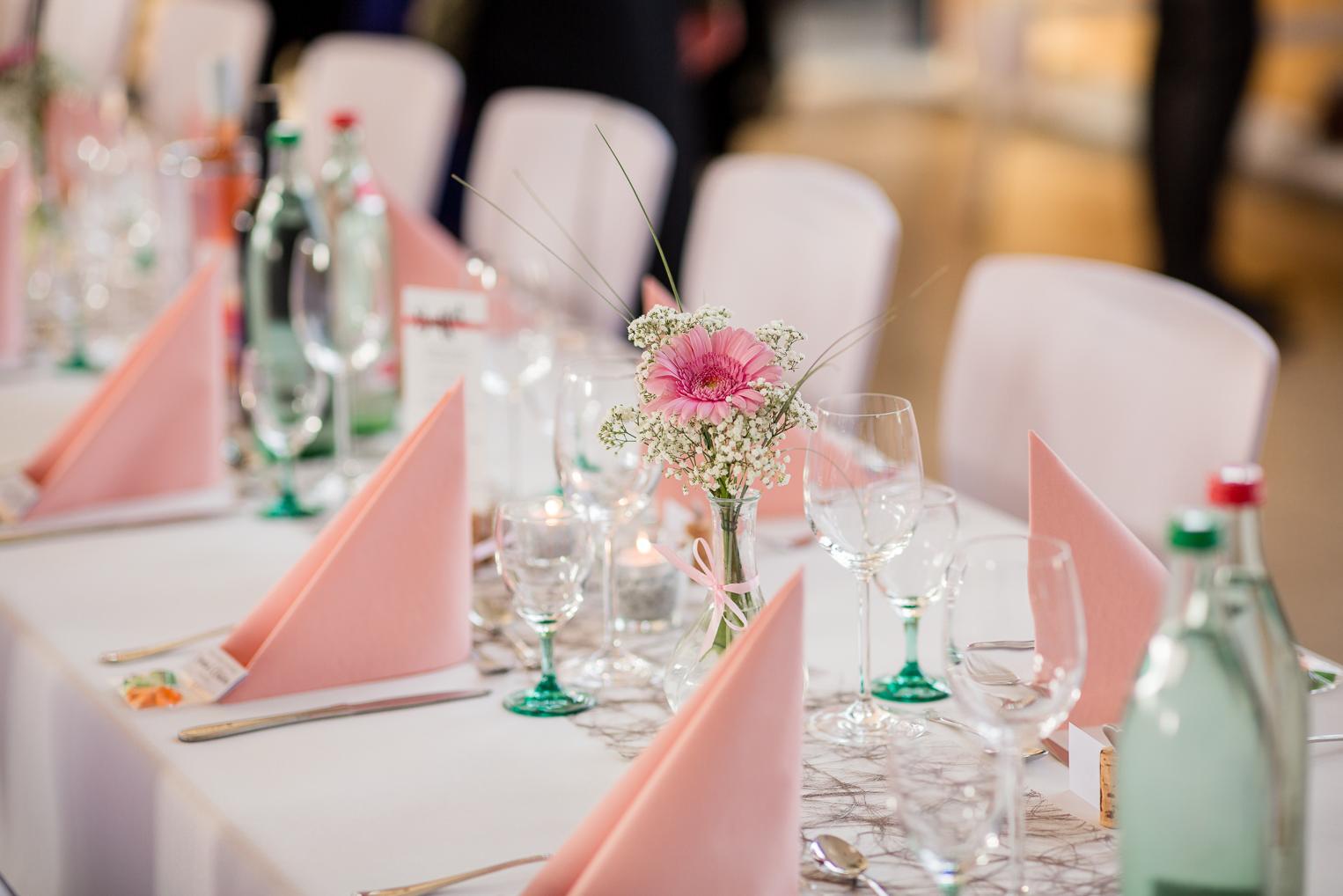 Tischdekoration Hochzeit Gruol: rosa Servietten, Gerbera und Schleierkraut in Vasen
