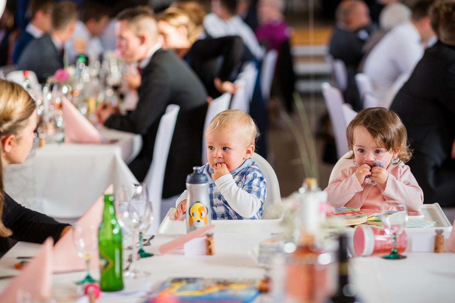 Zwei Kleinkinder am Hochzeitstisch beim Essen, lebendige Hochzeitsreportage Gruol