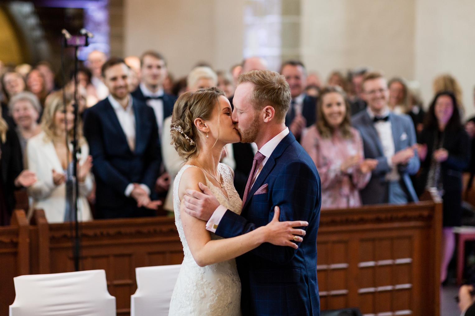 Hochzeitskuss nach dem Jawort in der Kirche Gärtringen – Gäste jubeln und klatschen