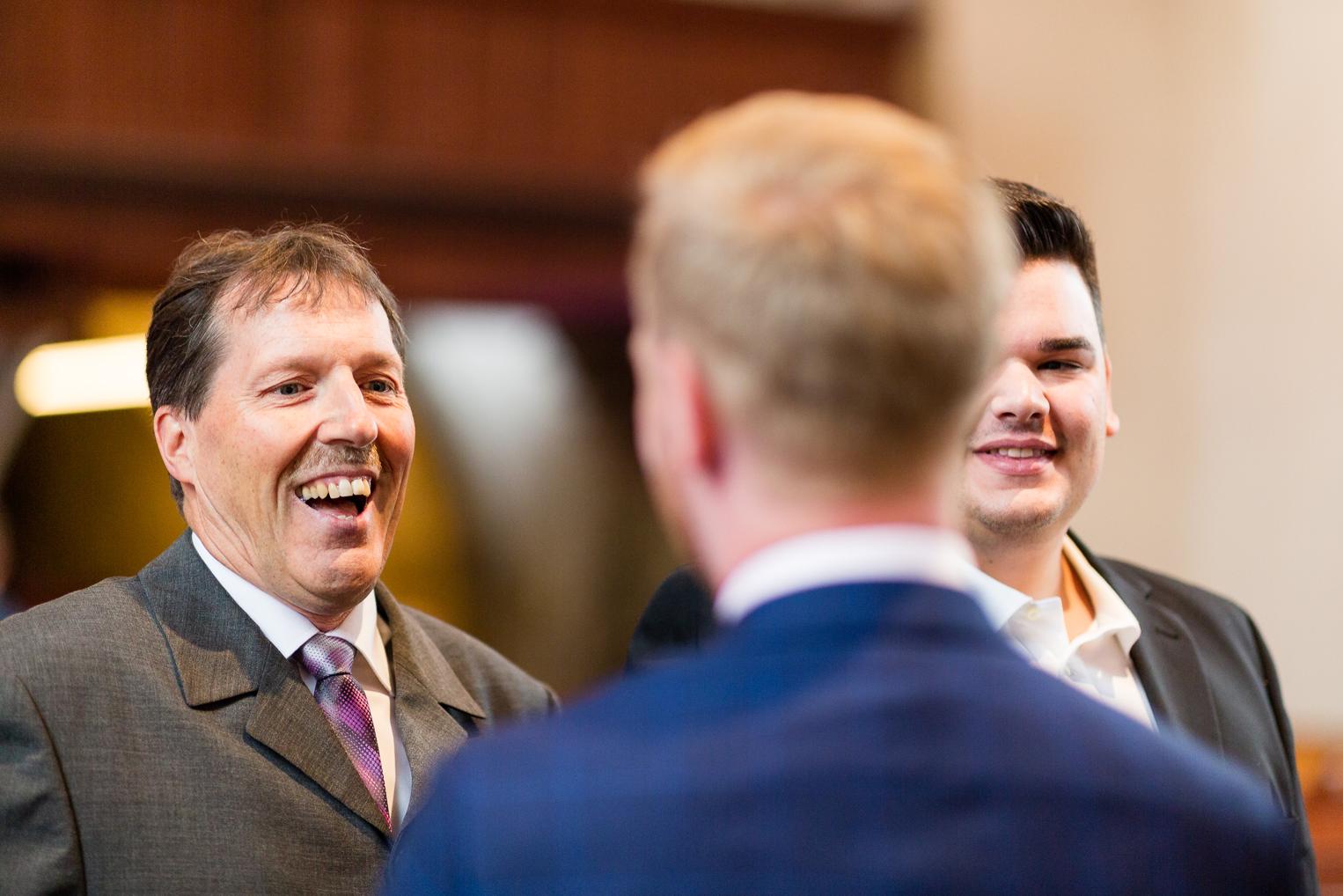 Gäste lachen herzlich mit dem Bräutigam beim Empfang nach der Hochzeit in Gärtringen