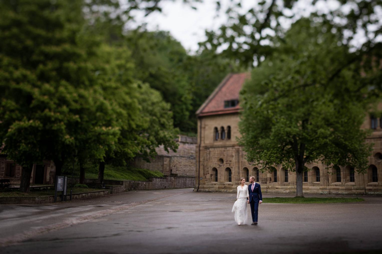 Brautpaar auf dem weitläufigen Klosterhof Maulbronn, Klostergebäude und Bäume im Hintergrund
