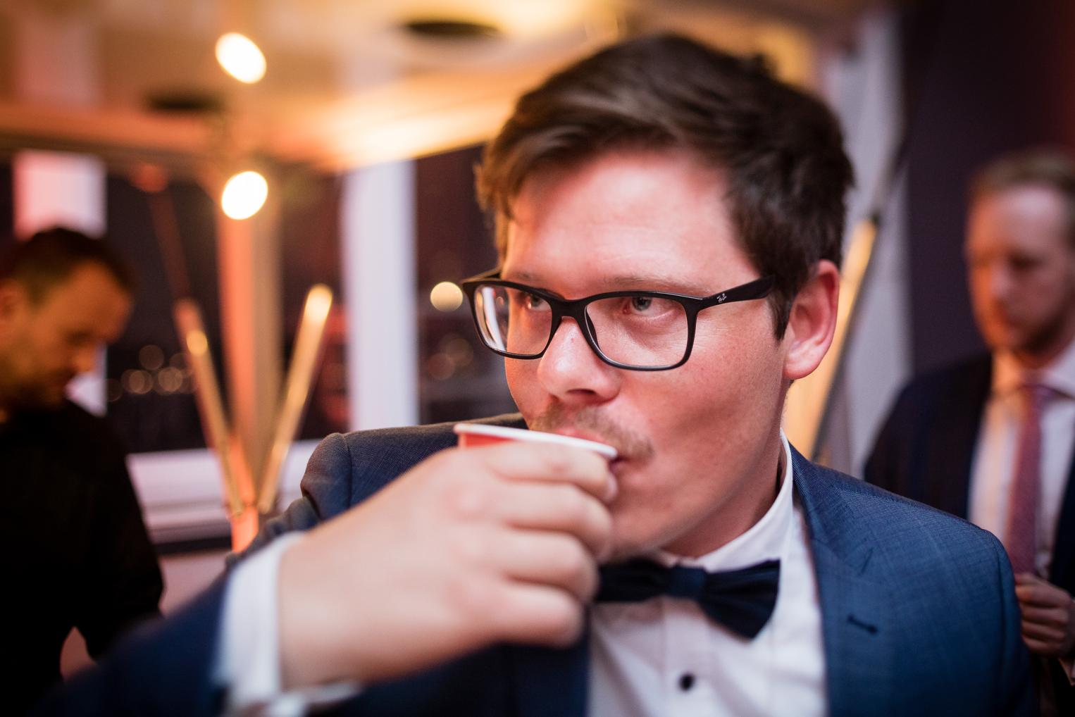 Gast trinkt aus einem roten Becher bei der Hochzeitsparty
