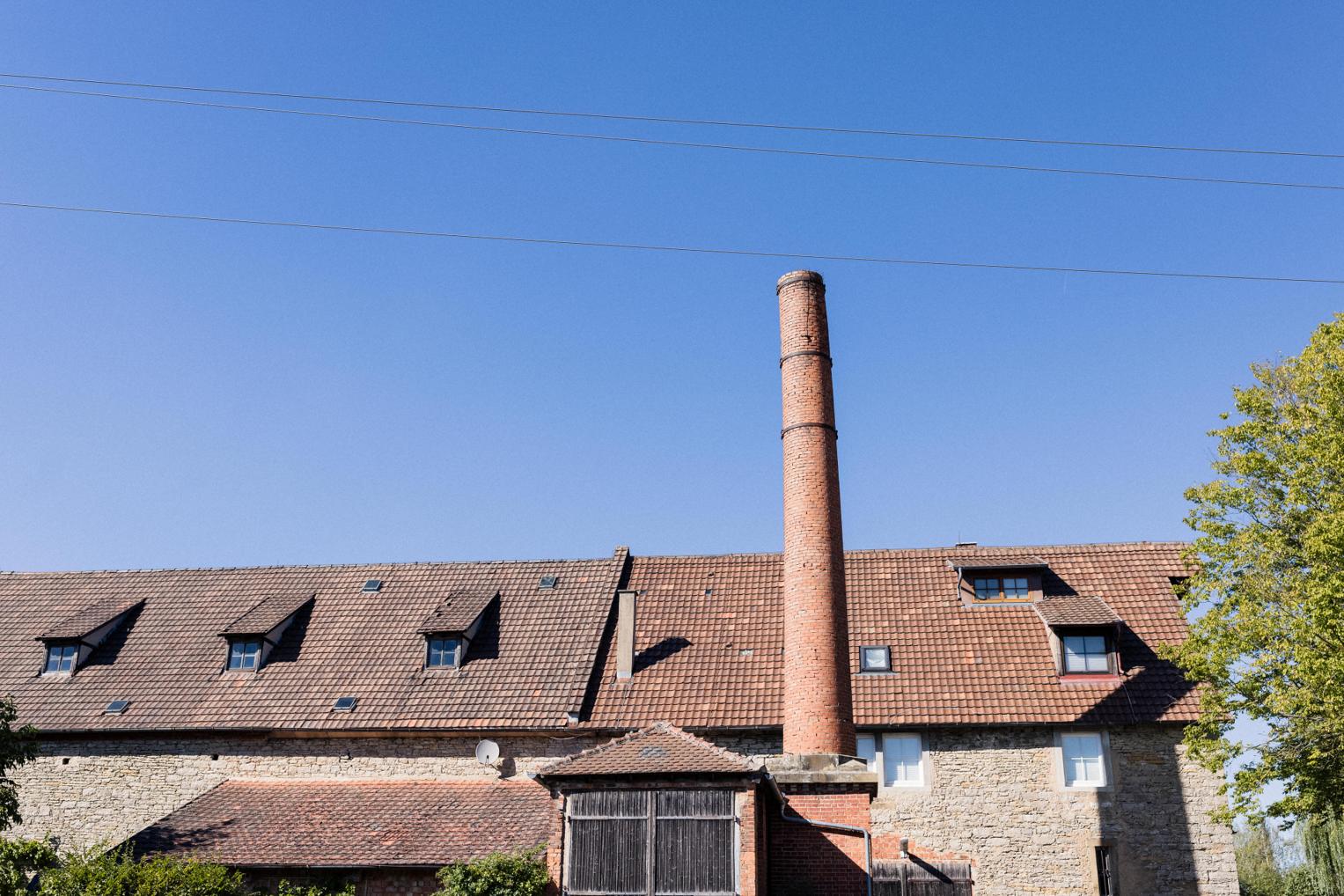 Backsteinschornstein und Dächer der Hofanlage Landgut Halsberg