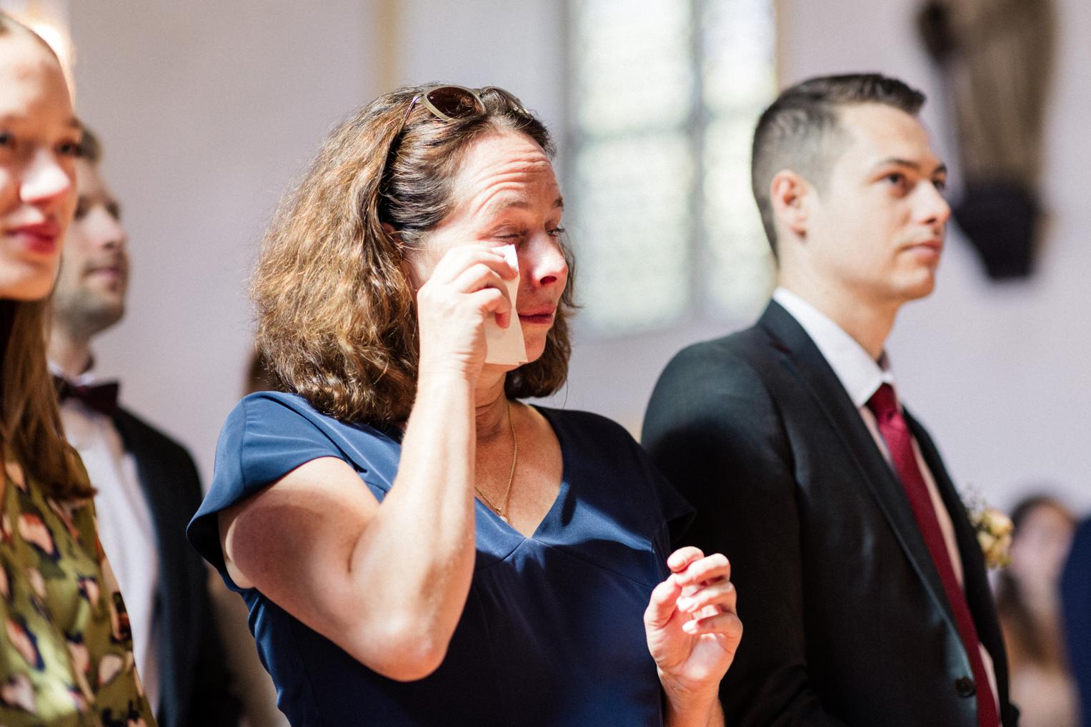 Mutter wischt sich gerührt eine Träne aus dem Auge