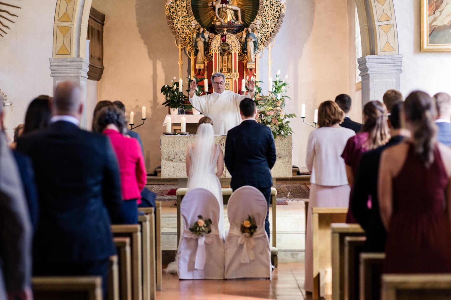Pfarrer spendet dem Brautpaar am Altar den Schlusssegen