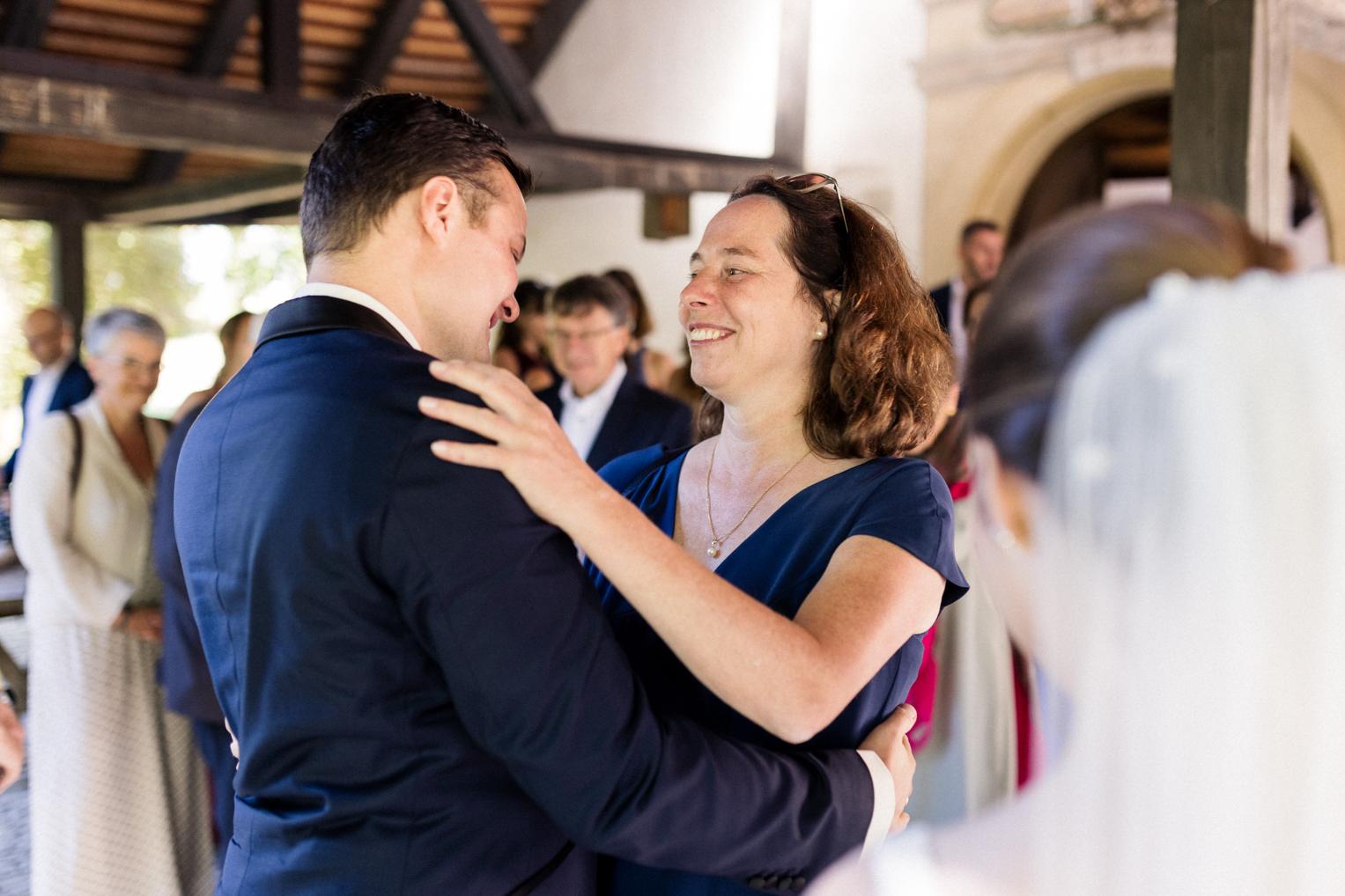Mutter gratuliert dem Bräutigam strahlend zur Hochzeit