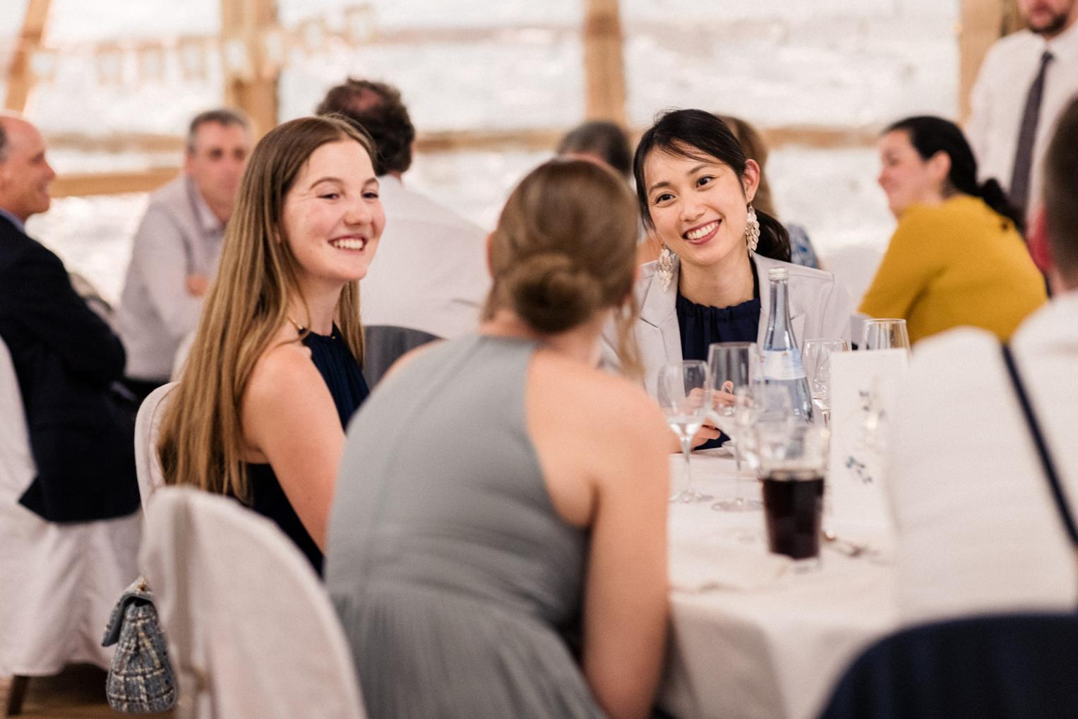 Freundinnen der Braut lachen am Hochzeitstisch