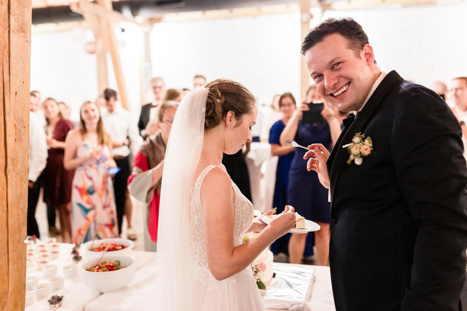 Bräutigam füttert seine Braut mit dem ersten Stück Hochzeitstorte