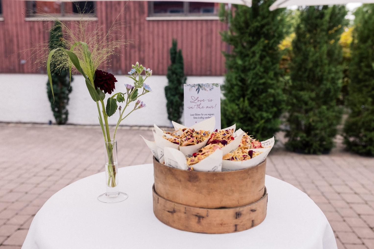 Tisch mit Streublüten-Tüten als Hochzeitsdeko im Innenhof der OaseWeil